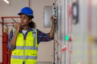 Kontrol odasında çalışan elektrik mühendisi. Elektrik mühendisi kontrol odasındaki güç dağıtım dolabını kontrol ediyor.