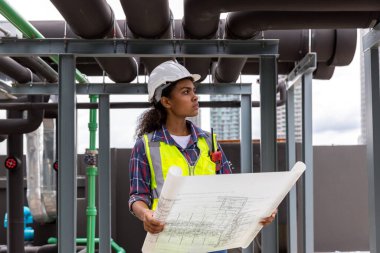 Engineers with draft plan of building on constructing site. Engineer working on building site. Engineer working with drawing System plan document