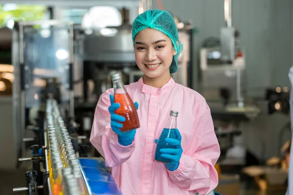 Woman worker using Checking quality or checking stock of products in beverage factory. Worker QC working in a drink water factory