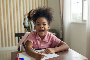 Girl is doing homework in the Classroom. Back to school! Cute industrious children are sitting at desks indoors. Kids are learning in class.