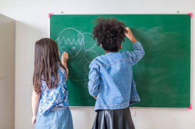 Kid write on chalk board. Back to school. Schoolchild in class. Happy kid writing green blackboard.