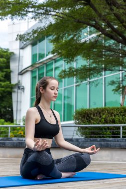 Woman doing yoga at outdoors garden. Woman is stretching in yoga at Garden. work out time