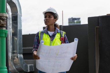 Engineers with draft plan of building on constructing site. Engineer working on building site. Engineer working with drawing System plan document