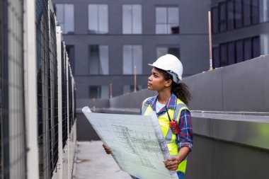 Engineers with draft plan of building on constructing site. Engineer working on building site. Engineer working with drawing System plan document