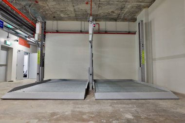 Empty Space in Automatic Elevator double stack car park. Hydraulic lift. Empty garage. Hydraulic machine for lifting car indoor parking.