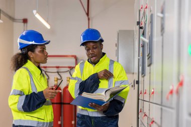 Kontrol odasında çalışan elektrik mühendisi. Elektrik mühendisi kontrol odasındaki güç dağıtım dolabını kontrol ediyor.