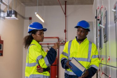 Kontrol odasında çalışan elektrik mühendisi. Elektrik mühendisi kontrol odasındaki güç dağıtım dolabını kontrol ediyor.