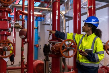 Engineer or technician work checking Fire suppression system and fire equipment. Engineer check red generator pump for water sprinkler piping and fire alarm control system