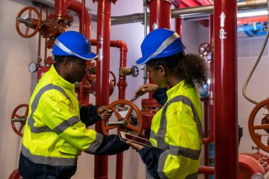 Engineer or technician work checking Fire suppression system and fire equipment. Engineer check red generator pump for water sprinkler piping and fire alarm control system