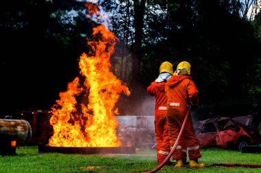 Firefighter Concept. Fireman using water and extinguisher to fighting with fire flame. firefighters fighting a fire with a hose and water during a firefighting training exercise