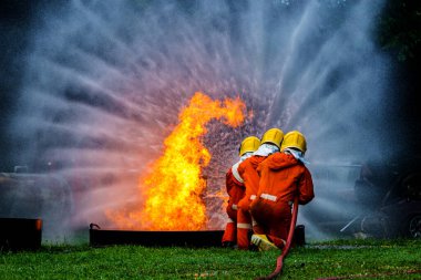 Firefighter Concept. Fireman using water and extinguisher to fighting with fire flame. firefighters fighting a fire with a hose and water during a firefighting training exercise
