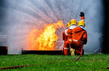 Firefighter Concept. Fireman using water and extinguisher to fighting with fire flame. firefighters fighting a fire with a hose and water during a firefighting training exercise