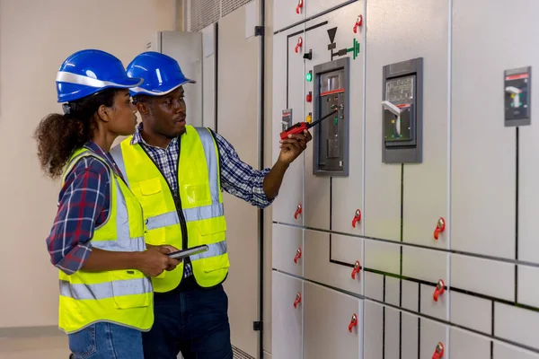 Electrical engineer working in control room. Electrical engineer man checking Power Distribution Cabinet in the control room