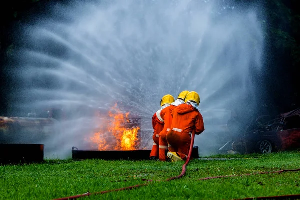 Firefighter Concept. Fireman using water and extinguisher to fighting with fire flame. firefighters fighting a fire with a hose and water during a firefighting training exercise