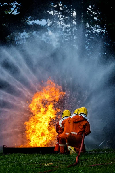 Firefighter Concept. Fireman using water and extinguisher to fighting with fire flame. firefighters fighting a fire with a hose and water during a firefighting training exercise