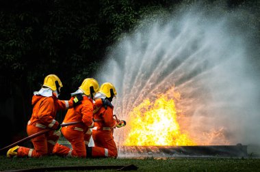 Firefighter Concept. Fireman using water and extinguisher to fighting with fire flame. firefighters fighting a fire with a hose and water during a firefighting training exercise
