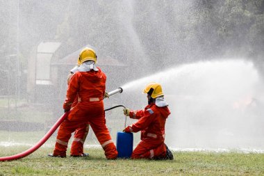 Firefighter Concept. Fireman using water and extinguisher to fighting with fire flame. firefighters fighting a fire with a hose and water during a firefighting training exercise