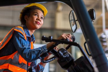 women worker at forklift driver happy working in industry factory logistic ship. Woman forklift driver in warehouse area.
