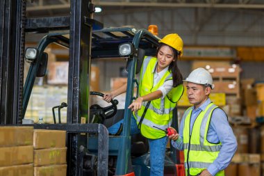 Fabrika lojistik gemisinde çalışan forklift şoförü. Kadın forklift sürücüsü depo alanında..