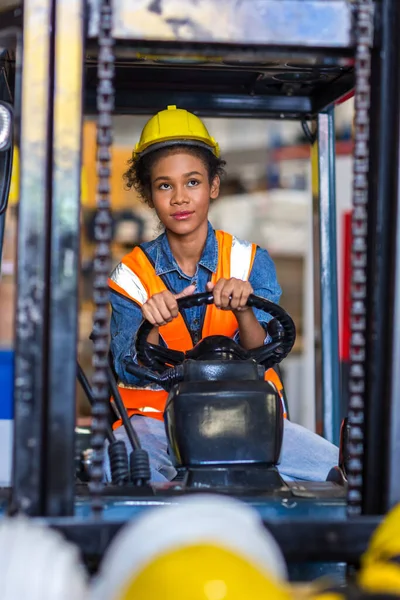 women worker at forklift driver happy working in industry factory logistic ship. Woman forklift driver in warehouse area.