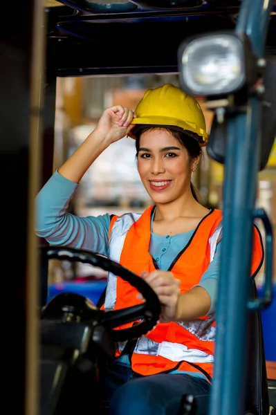 women worker at forklift driver happy working in industry factory logistic ship. Woman forklift driver in warehouse area.