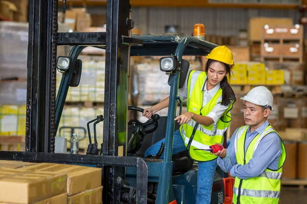 Fabrika lojistik gemisinde çalışan forklift şoförü. Kadın forklift sürücüsü depo alanında..