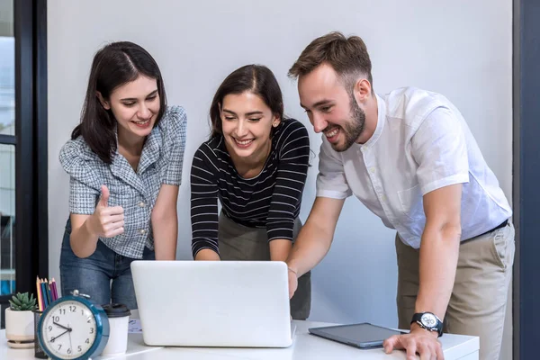 Group friend watching funny video online. Happy and Fun friends using laptop together in office