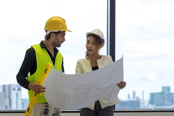 Team Engineers with draft plan of building on constructing site. Engineer work on site. engineer visit and inspection site engineer. Inspector engineer check and working on site.