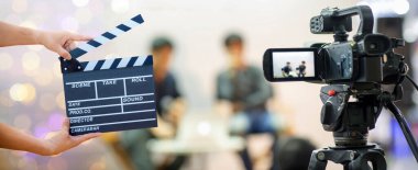 Adam elleri film alkışını tutuyor. Film yönetmeni konsepti. Kamera görüntüsünü göster. Röportajda ya da düğün töreninde görüntüyü yakala. En iyi anma günü konseptinde durdurulmuş hareketi yakala.