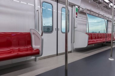 Metro treninin içinde içi kırmızı renkte olan boş koltuklar. Boş koltuklu metro. Bir tren vagonunda.