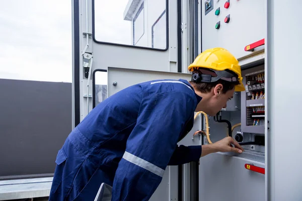 Electrical engineer working in control room. Electrical engineer man checking Power Distribution Cabinet in the control room