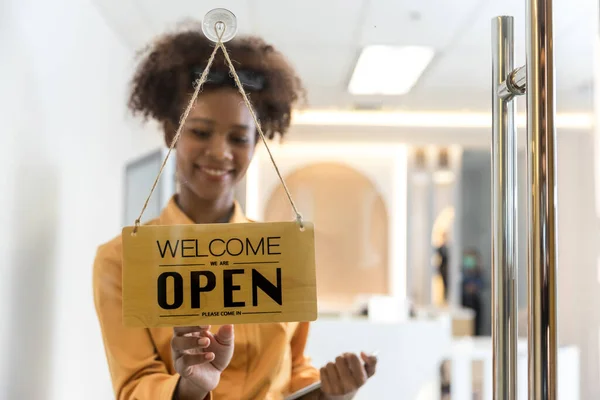 A business sign that word Open on cafe or restaurant hang on door at entrance. Small business  owner turning the sign for the reopening