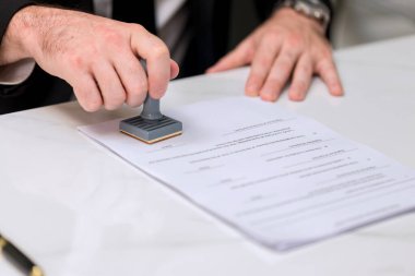 Belgede Onaylanmış Damga İle İşadamı Damgası. İş dünyası pul ve sertifika konseptini onaylıyor. İş Adamı Eller Belgeyi Damgalıyor