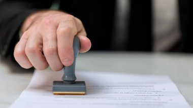 Belgede Onaylanmış Damga İle İşadamı Damgası. İş dünyası pul ve sertifika konseptini onaylıyor. İş Adamı Eller Belgeyi Damgalıyor