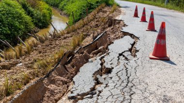 Yağmurun yol açtığı toprak kayması bozuk yol asfaltında meydana gelir. Kırık asfalt yol çöktü ve düştü. Yol çöker. Çatlak asfalt yol. İnşaat alanı.