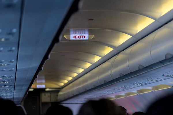 Exit sign in passenger airplane. Emergency exit sign on airplane. Exit airplane sign