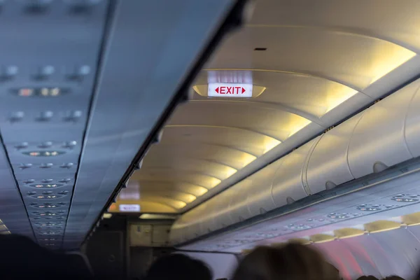 Exit sign in passenger airplane. Emergency exit sign on airplane. Exit airplane sign