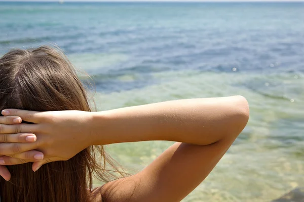 Chica joven tomar el sol y relajarse en la playa — Foto de Stock