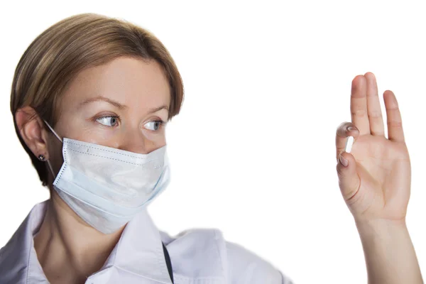 Woman doctor on a white background in a mask looking at tablet — Stock Photo, Image