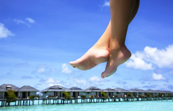 Female legs and turquoise sea — Stock Photo, Image