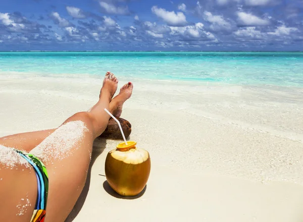 Green coconut and legs of a young girl — Stock Photo, Image