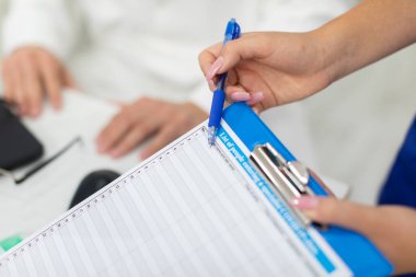 Doktorların ofisinde, doktorlar COVID-19 bildirisini nasıl dolduracaklarını açıkladılar.