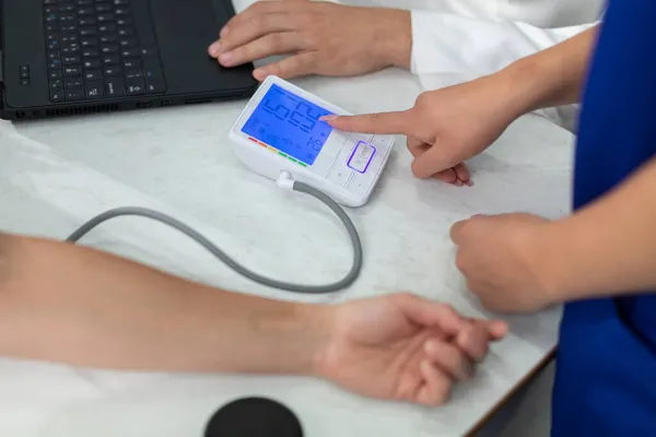 The nurse shows the total blood pressure result. — Stock Photo, Image