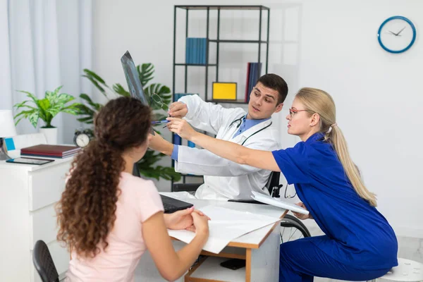Médicos no consultório discutem seus pacientes com radiografia pulmonar. — Fotografia de Stock