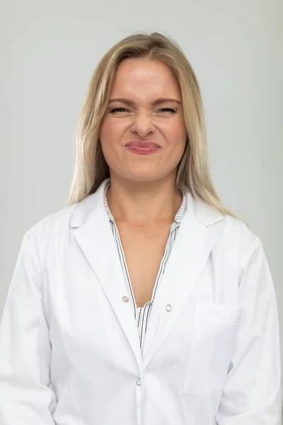 Portrait of a lady doctor with a sour face in a white apron. — Stock Photo, Image