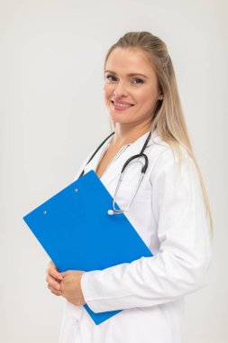 Gülümseyen bir doktor belgeleri mavi bir klasörde tutuyor..