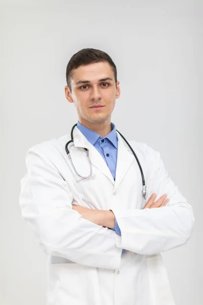 The doctor stands forward with folded arms with a gentle smile. — Stock Photo, Image