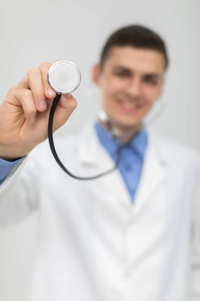 Il dottore prende il suo stetoscopio e lo posiziona direttamente sulla telecamera. Sorride.. — Foto Stock