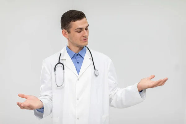 The doctor spreads his arms from side to side and leaves the choice to the patient. — Stock Photo, Image