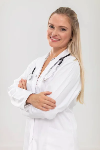Eine lächelnde Ärztin steht mit gefalteten Händen vor der Kamera. — Stockfoto